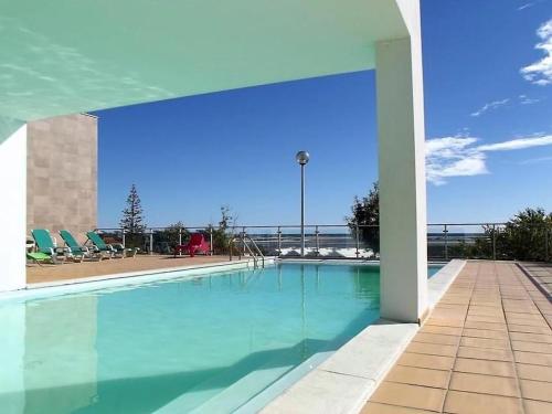 a large swimming pool with blue water and chairs at Fuseta Apartments - Bela Vista & Vista Mar - Penthouses in Fuzeta