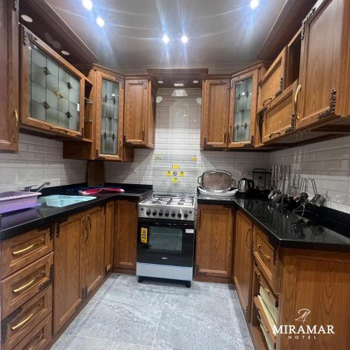 a kitchen with wooden cabinets and a stove top oven at Miramar Boutique Hotel in Alexandria