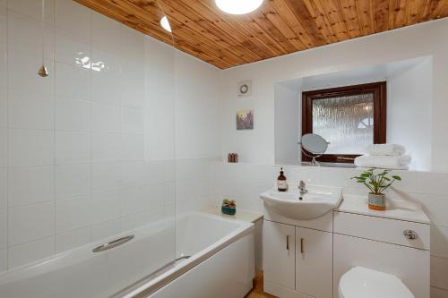 a bathroom with a tub and a sink and a toilet at Georgian period property w/large enclosed garden in Crieff