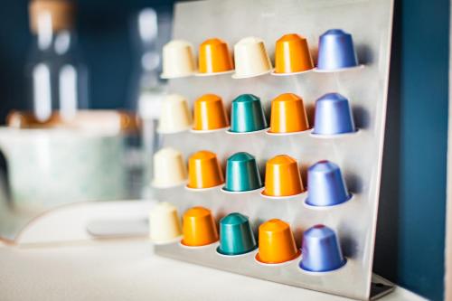 a white shelf with colorful cups on it at L'Appart du Quai avec Terrasse in Strasbourg