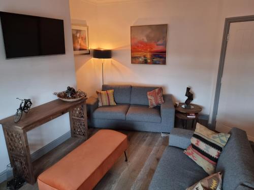 a living room with a couch and a tv at Apartment 11, Mirfield, West Yorkshire in Mirfield