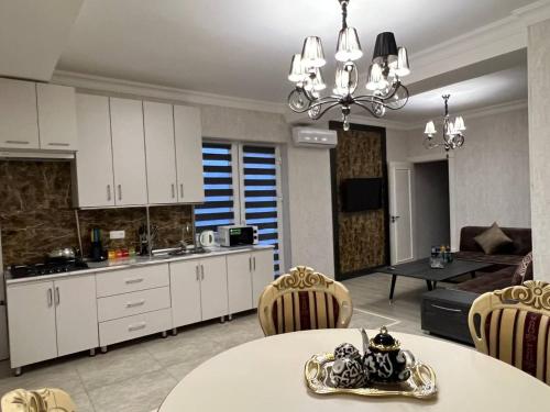 a kitchen and living room with a table and chairs at Orient INN Apartment in Tashkent
