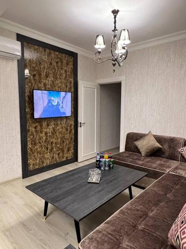 a living room with a couch and a table at Orient INN Apartment in Tashkent