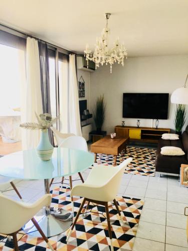 sala de estar con mesa de cristal y sillas blancas en Les hauteurs de la Capelette en Marsella