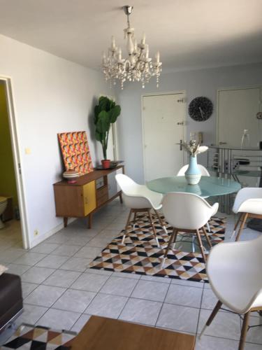 une salle à manger avec une table en verre et des chaises blanches dans l'établissement Les hauteurs de la Capelette, à Marseille