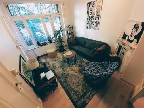 an aerial view of a living room with a green couch at Belle Époque Apartment close to EU, NATO & RTBF in Brussels