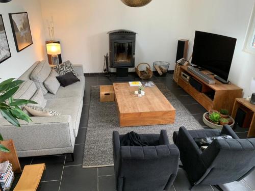 - un salon avec un canapé et une cheminée dans l'établissement Ferme rénovée 300M2 La Casa JEB : Charme, Calme et Nature, à Moncheaux