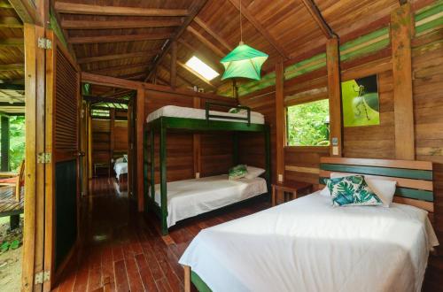 a bedroom with two beds in a wooden cabin at El Almejal in El Valle