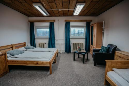 - une chambre avec deux lits et une chaise dans l'établissement U Ztraceného potoka, à Vápenná
