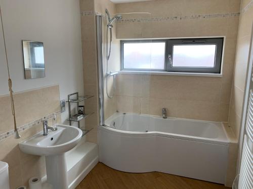 a bathroom with a sink and a bath tub and a sink at Central Darlington Apartment With Parking in Darlington