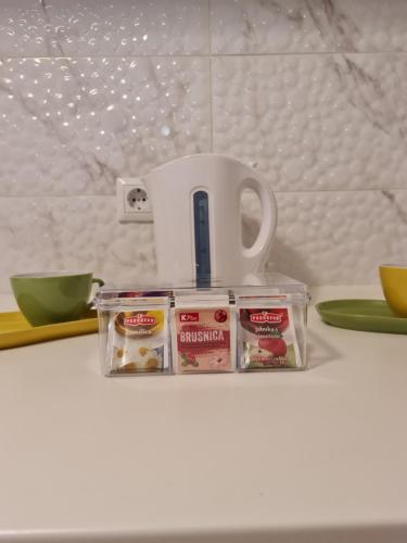 a plastic container of food and a cup on a counter at Apartment Pemper - Self check in and check out in Otočac