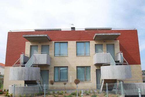 a building with balconies on the side of it at Apartamentos Playa de Portio in Liencres