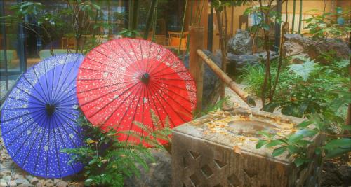 three umbrellas are sitting in a garden at Richmond Hotel Premier Kyoto Ekimae in Kyoto