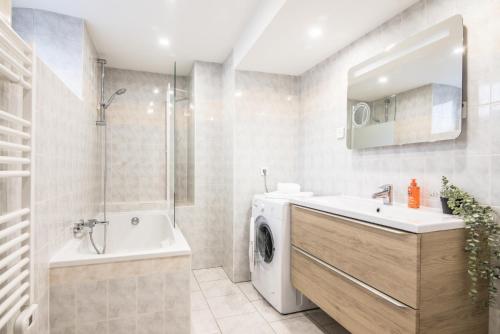 een badkamer met een wastafel en een wasmachine bij Centre ville - L'Aventurier - Parking in Drulingen