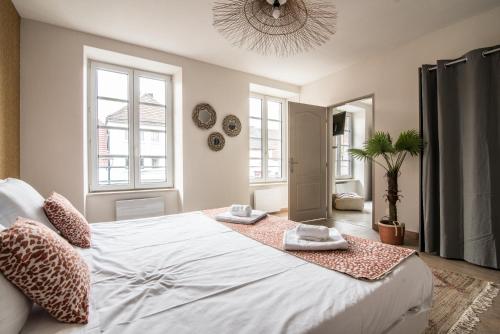 een slaapkamer met een groot wit bed en 2 handdoeken bij Centre ville - L'Aventurier - Parking in Drulingen