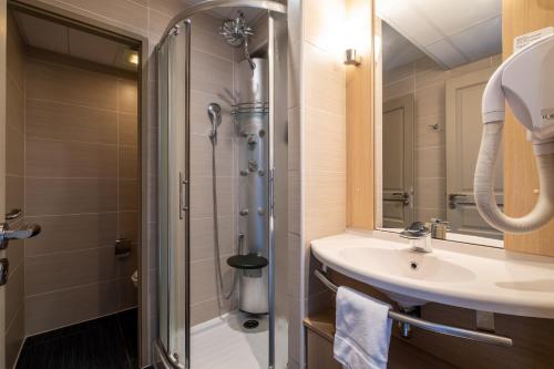 a bathroom with a sink and a shower at Clarion Aparthotel Toulouse Blagnac Airport in Blagnac