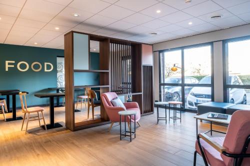 a fast food restaurant with chairs and tables at Clarion Aparthotel Toulouse Blagnac Airport in Blagnac