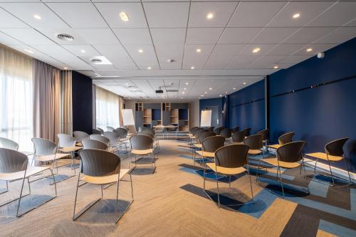 a room with rows of chairs and blue walls at Clarion Aparthotel Toulouse Blagnac Airport in Blagnac