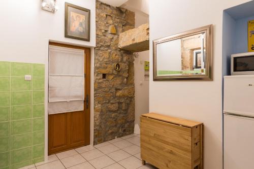 una cucina con frigorifero e un muro in pietra di DIFY Saone - Vieux Lyon a Lione