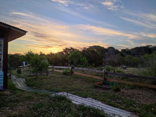 a fence in a field with the sunset in the background at Biodiversidad posada familiar in La Pedrera