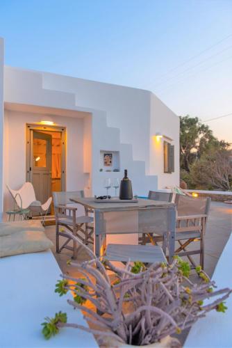 a patio with a table and chairs and a table and chairs at Villa Arades Sifnos with Private Pool in Apollonia