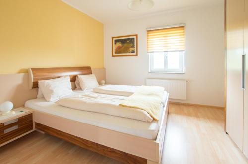 a bedroom with a large bed with white sheets at Ferienhof Neundlinger in Niederwaldkirchen