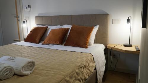 1 dormitorio con 1 cama grande y 2 almohadas en Atenea Palace Rooms, en Agrigento