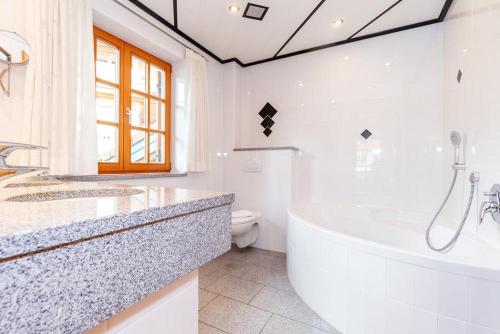 a white bathroom with a tub and a toilet at Ferienwohnung Anna in Reit
