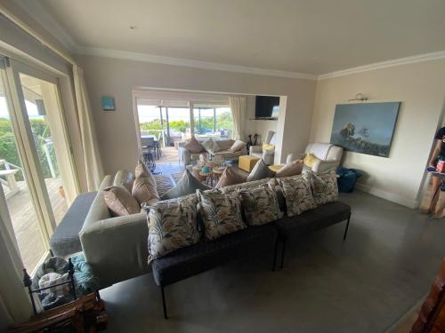 a living room with a couch and a table at Lasalle holiday home (Sun, Beach, Views, Fun for everyone!) in Plettenberg Bay
