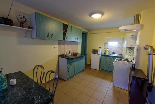 a kitchen with green cabinets and white appliances at Árnyas vendégház, Füge apartman in Balatonboglár