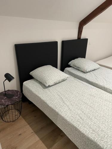 two beds sitting next to each other in a room at Magnifique corps de ferme rénové avec Jacuzzi in Hillion