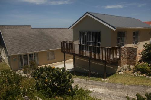 a house with a porch and a balcony at Aloe Ocean Flatlet in Bettyʼs Bay