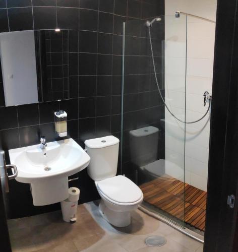 a bathroom with a toilet and a sink and a shower at Albergue La Estación in Cehegín