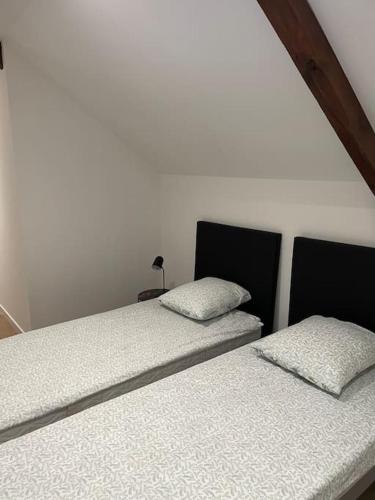 deux lits côte à côte dans une pièce dans l'établissement Magnifique corps de ferme rénové avec Jacuzzi, à Hillion