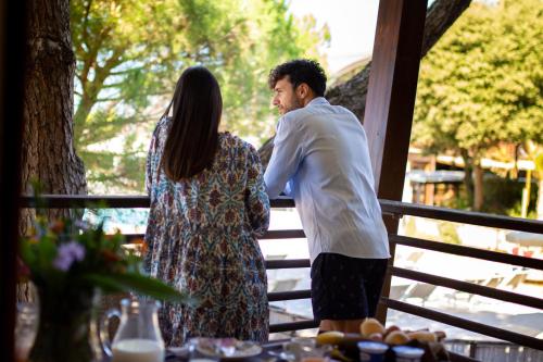 a man and a woman standing next to a fence at Canado Club Family Village in Marina di Castagneto Carducci