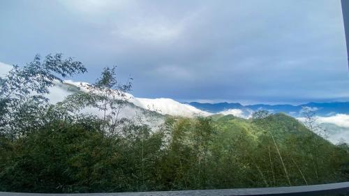 a view of a mountain with trees and clouds at SunSweet House in Fanlu