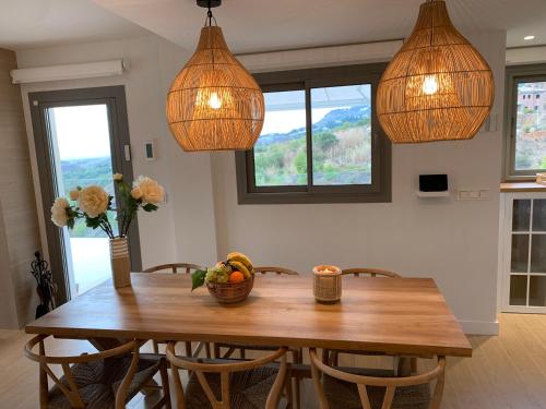 a dining room with a wooden table with chairs and lights at Casa Carolina - This One in Higuerón with Quality and Peace in Mijas