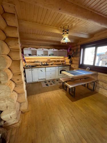 a kitchen with a table in a log cabin at Будиночок-зруб в центрі Пилипця in Pilipets