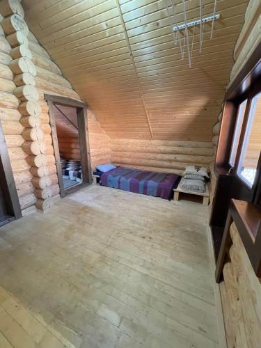 an empty room with a bed in a log cabin at Будиночок-зруб в центрі Пилипця in Pilipets