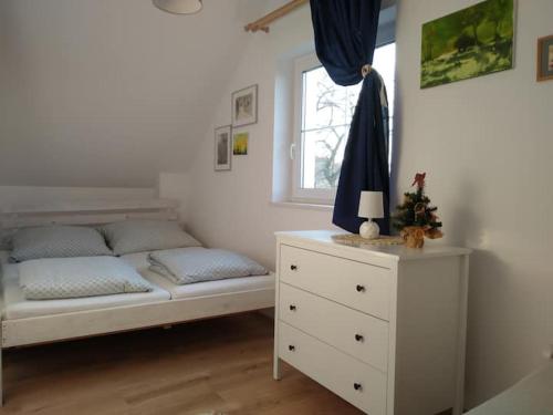 a bedroom with a bed with a dresser and a window at Domek w Białej - Mak in Marcinowice