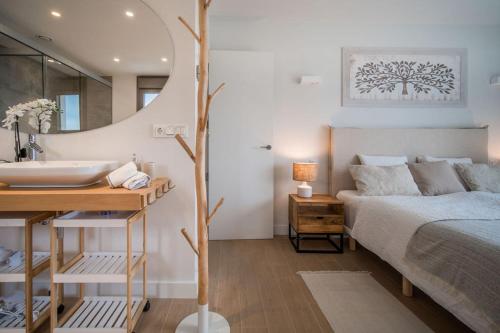 a bedroom with a bed and a sink and a mirror at Casa Carolina - This One in Higuerón with Quality and Peace in Mijas