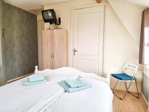 a bedroom with a white bed with two towels on it at Landelijk gelegen vakantiestudio ME02 in Meliskerke