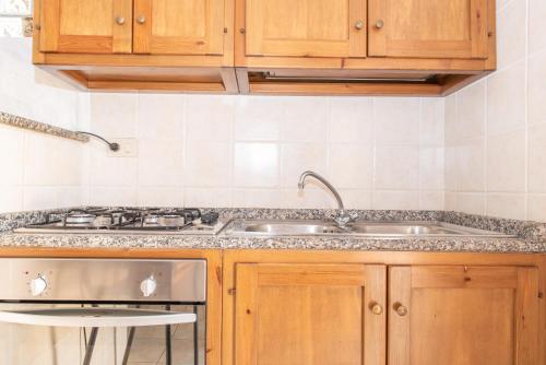 a kitchen with wooden cabinets and a sink and a stove at Casa Pasqualina in San Giovanni