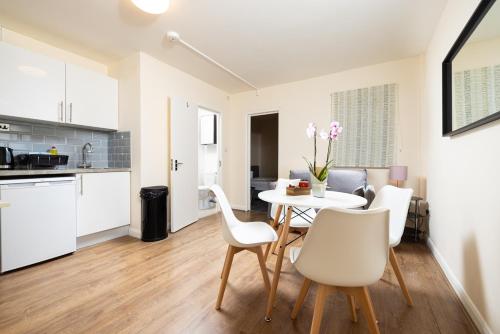 a kitchen and dining room with a table and chairs at Charmstay King's Cross in London