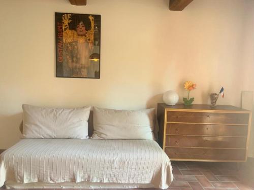 una camera con un letto e un comò con una foto sul muro di Andromeda apartment a Montespertoli