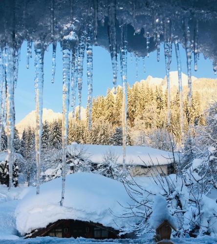 a bunch of icicles hanging from a roof in the snow at Ferienhaus Chalet Kitzalp in Sankt Johann in Tirol