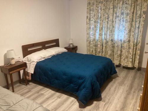1 dormitorio con 1 cama con manta azul en Apartamento Turístico Cervantes 18, en Losar de la Vera