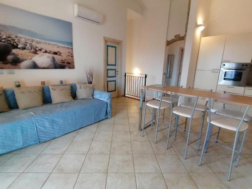 sala de estar con sofá, mesa y sillas en Sardamare Apartments Appartamenti La Ciaccia, en Valledoria