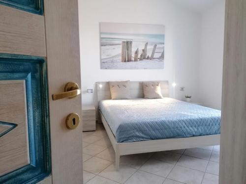 瓦雷多利亚Sardamare Apartments Appartamenti La Ciaccia的卧室配有一张床,墙上挂有绘画作品