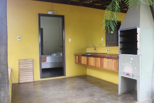 a yellow bathroom with a sink and a mirror at Pousada e Camping Carrion in Itu